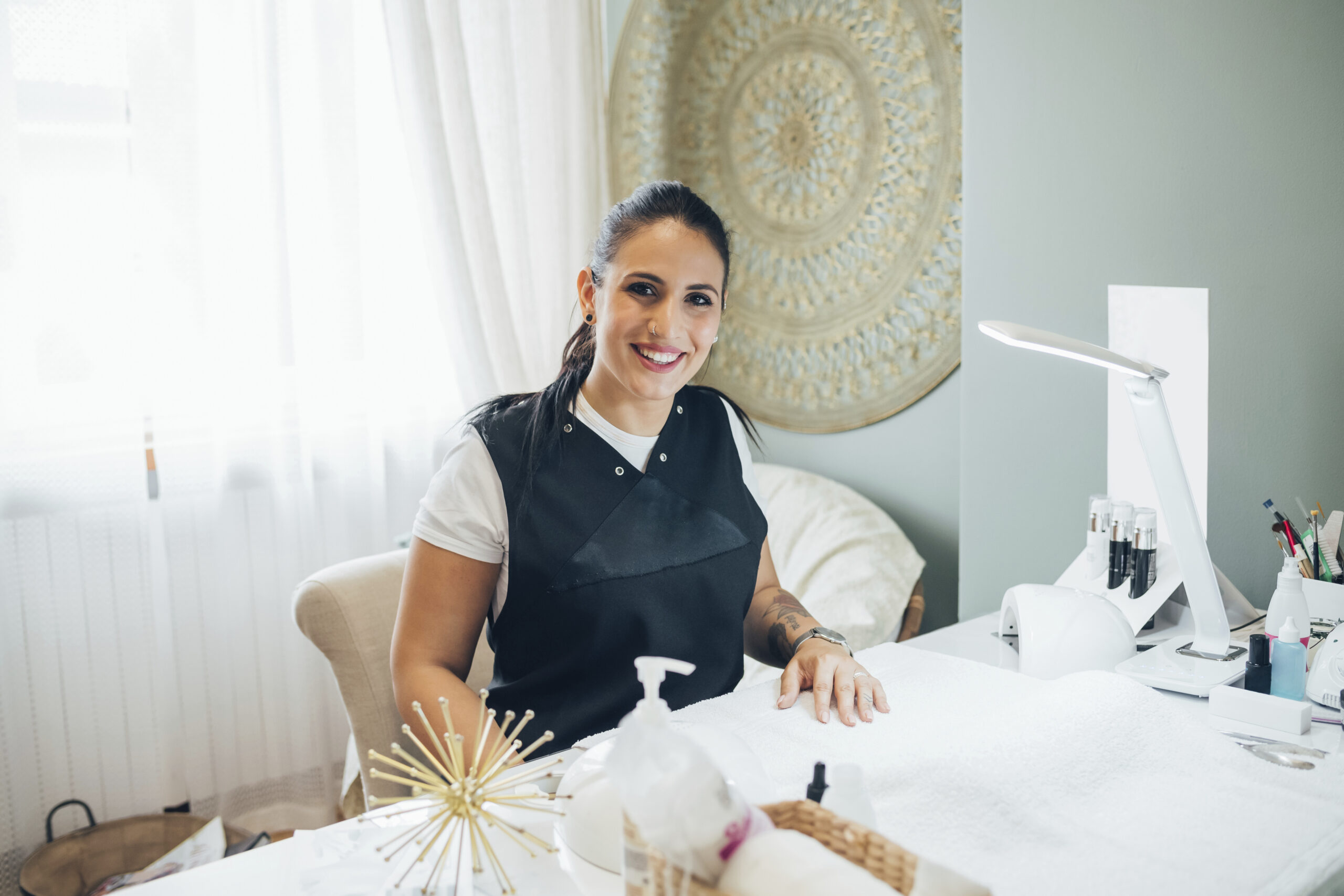 Smiling professional at a beauty treatment station.