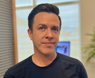 Man in black shirt smiling indoors